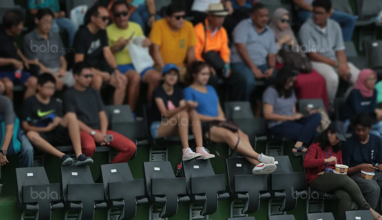 Aksi sejumlah penonton mengangkat kaki pada sandaran kursi saat laga Piala Davis 2018 grup dua Asia/Oceania di Senayan, Jakarta, Sabtu (4/2/2018). Renovasi Lapangan Tenis ini memakan biaya sekitar 92 miliar rupiah.  (Bola.com/Nick Hanoatubun)