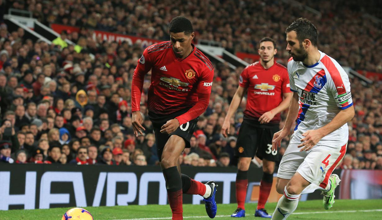 Aksi Marcus Rashford mencoba melewati pemain Crystal Palace, Luca Milivojevic pada laga lanjutan Premier League yang berlangsung di stadion Old Trafford, Manchester, Minggu (25/11). MU bermain imbang 0-0. (AFP/Lindsay Parnaby)