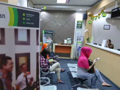 Warga saat menunggu transaksi di pegadaian di Jakarta, Rabu (29/6). Transaksi gadai di kalangan masyarakat diprediksi akan terus alami peningkatan selama bulan Ramadan hingga Juli. (Liputan6.com/Angga Yuniar)
