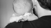 Si bayi Ted tampak anteng dalam gendongan ayah, siapa sangka ia beri kejutan untuk ayahnya yang terekam dalam bidikan Kirsty Grant. (Foto: Daily Mail))