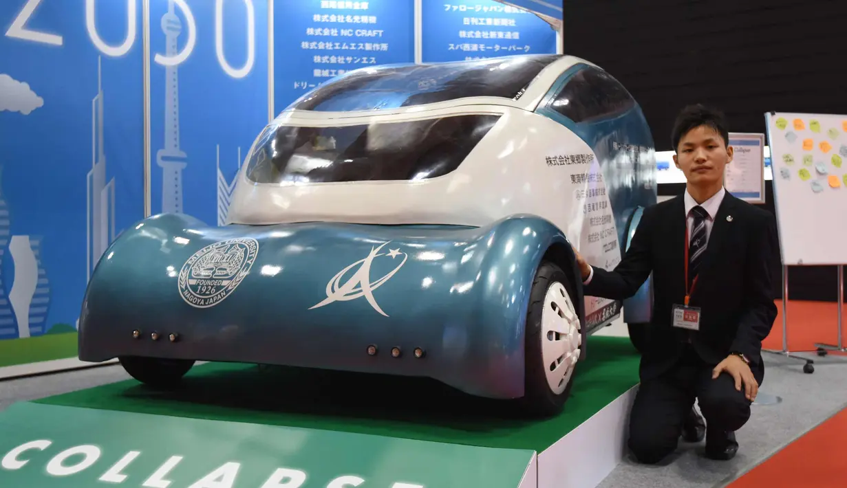 Pengunjung berpose di samping Collapse, kendaraan listrik ringan di Tokyo Motor Show, Jepang (25/10). Mobil ini diracang sebagai bagian dari kegiatan sekolah, mobil ini mengunakn kontroler PlayStation untuk dikendarai. (AFP Photo/Toru Yamanaka)