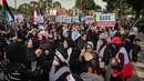 Peringatan Hari Al-Quds Internasional dicetus oleh Ayatollah Khomeini pada 1979, momen ini melibatkan aksi pawai damai di berbagai negara, termasuk Indonesia. Tampak dalam foto, orang-orang memegang plakat dan bendera Palestina selama aksi unjuk rasa memperingati Hari Al-Quds, di Surabaya, Jawa Timur, Jumat (13/3/2026). (Juni KRISWANTO/AFP)
