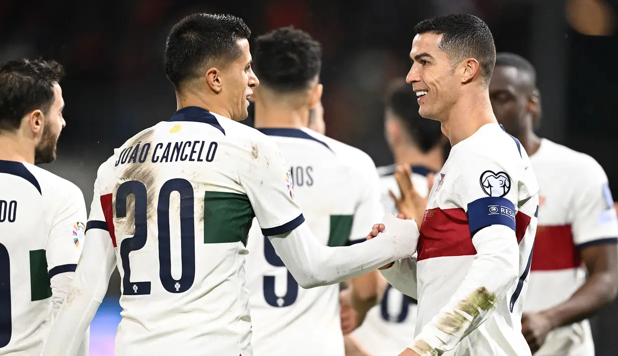 Selebrasi striker Timnas Portugal, Cristiano Ronaldo (kanan) bersama rekannya, Joao Cancelo setelah mencetak gol pembuka ke gawang Liechtenstein pada laga lanjutan Grup J Kualifikasi Euro 2024 di Rheinpark Stadium, Vaduz, Jumat (17/11/2023) dini hari WIB. (AFP/Sebastien Bozon)