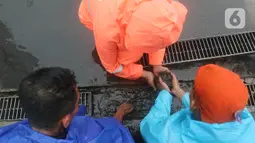 Petugas Penanganan Prasarana dan Sarana Umum (PPSU) membersihkan saluran air di kawasan Gelora Bung Karno, Jakarta, Selasa (17/12/2019). Petugas PPSU membersikan saluran air saat terjadi genangan usai hujan deras mengguyur Jakarta. (Liputan6.com/Herman Zakharia)