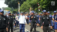 Menteri Komunikasi dan Informatika, Rudiantara (tengah) berlari membawa obor saat kirab obor Asian Games 2018 mengelilingi Kota Bogor, Jawa Barat, Selasa (14/8). Kota Bogor menjadi kota terakhir kegiatan pawai obor Asian Games. (Merdeka.com/Arie Basuki)