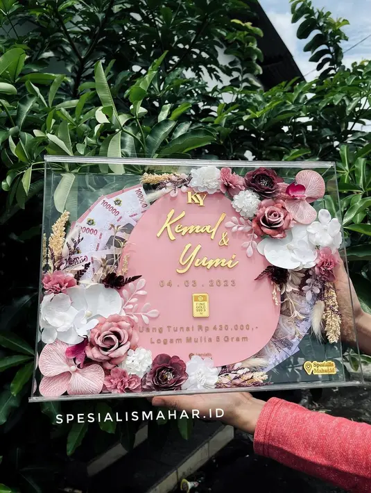 <p>Potret mas kawin yang diberikan Kemal terhadap Yumi dalam sebuah bingkai. Aktor kelahiran Samarinda 33 tahun lalu itu memberikan mas kawin uang tunai Rp 430.000,- dan logam mulia 5 gram yang dirangkai cantik. [Instagram/spesialismahar.id]</p>