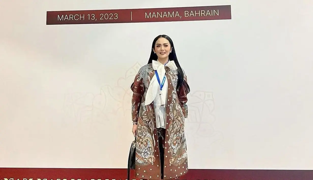Krisdayanti tampil menarik mengenakan blazer panjang batik dipadukan kemeja putih pita dan roknya. [@krisdayantilemos]