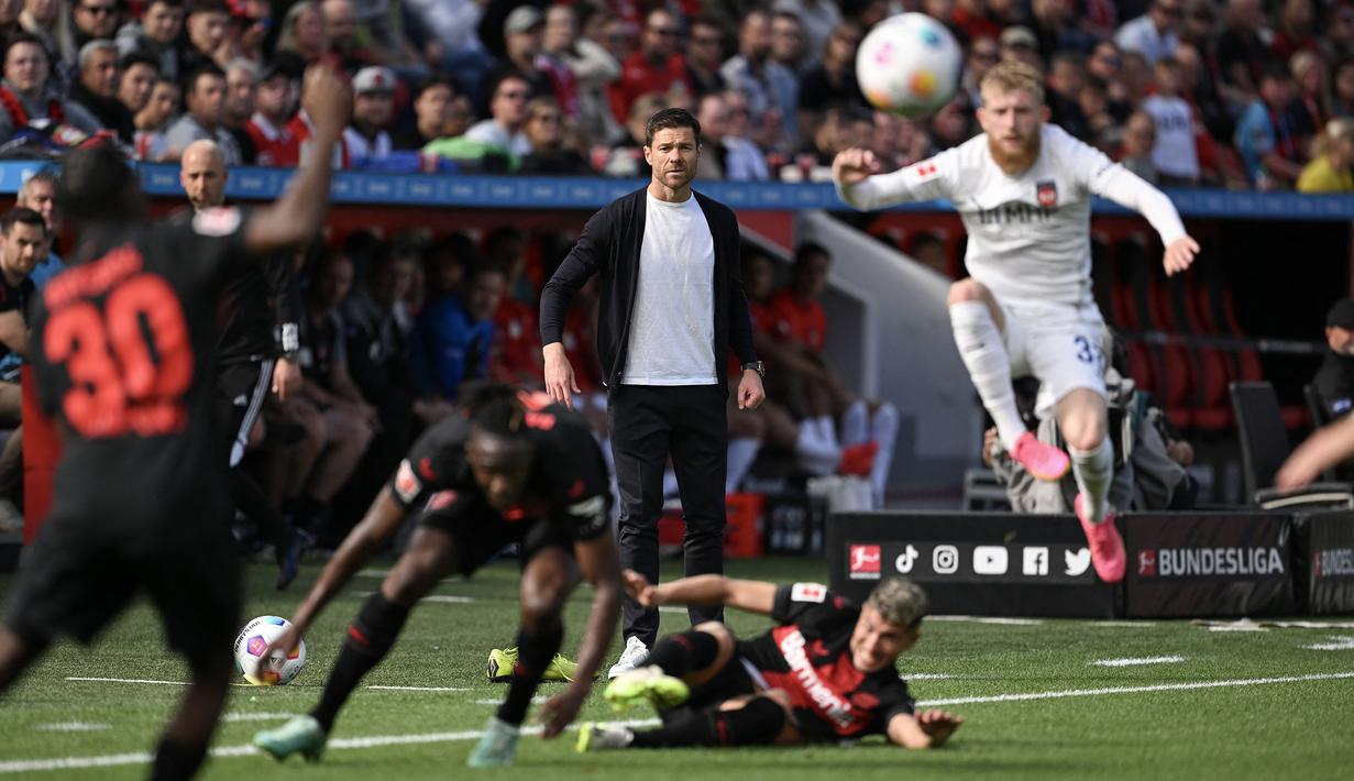 Pelatih Bayer Leverkusen, Xabi Alonso (tengah) melihat pemainnya berebut bola dengan pemain FC Heidenheim pada laga lanjutan Bundesliga di Leverkusen, Jerman, 24 September 2023. (AFP/Ina Fassbender)