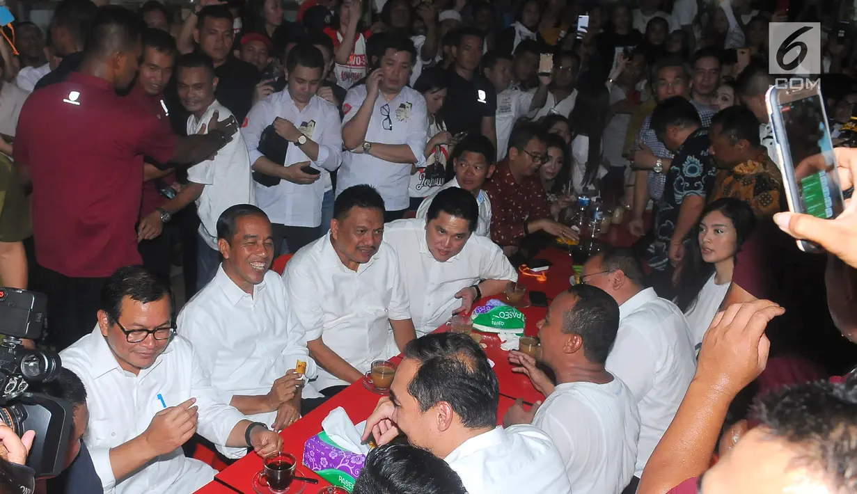 Capres nomor urut 01 Joko Widodo atau Jokowi, Politikus PDIP Pramono Anung, Gubernur Sulut Olly Dondokambey dan Ketua TKN Erick Thohir saat ngopi di Jalan Roda, Manado, Minggu (31/3). Sambil menikmati kopi Jokowi bercerita pengalaman uniknya ketika berkunjung ke Sulut. (Liputan6.com/Angga Yuniar)