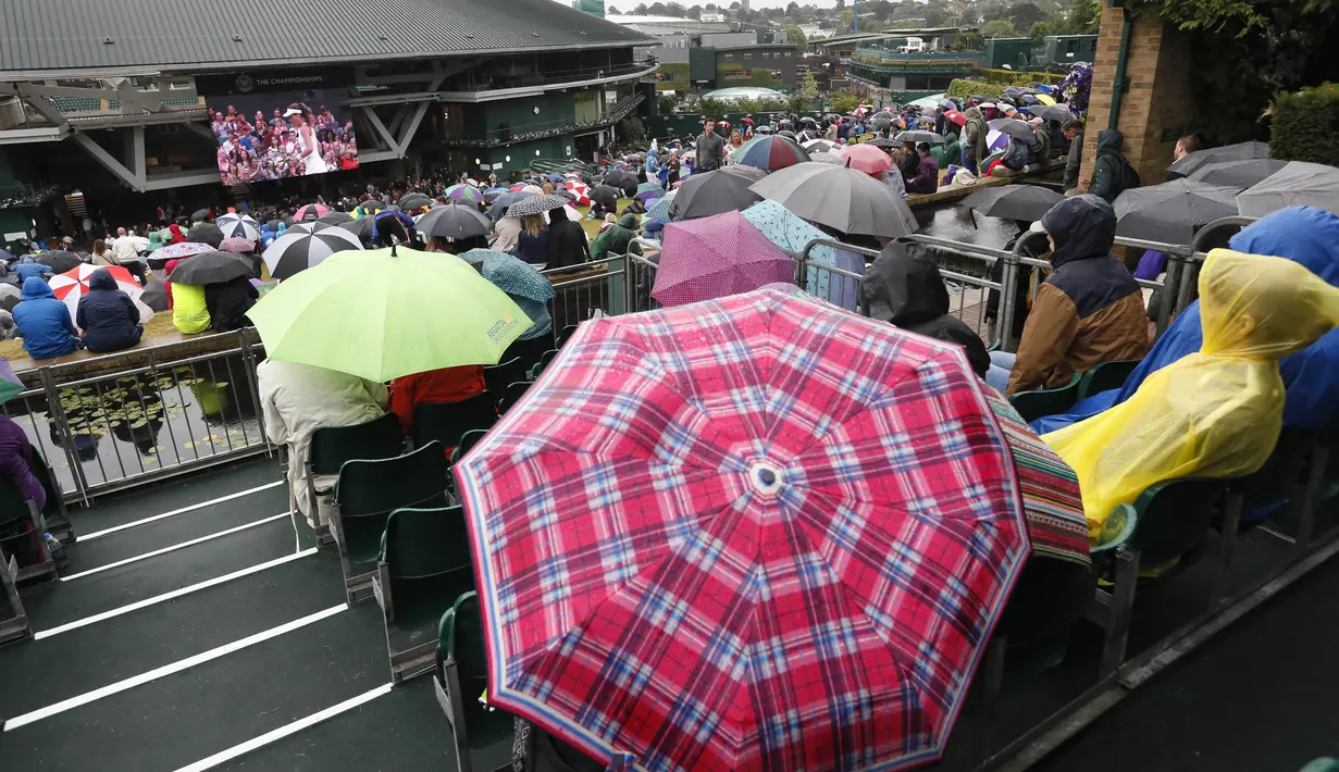 Warna-warni payung yang digunakan penonton saat menyaksikan laga tenis Wimbledon dari layar di The All England Lawn Tennis Club, London, (11/7/2017). (AP/Kirsty Wigglesworth)
