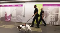 Anggota polisi kereta wilayah Ile de France bersama Lina seekor anjing jenis Spaniel yang terlatih untuk mendeteksi bahan peledak berpatroli di sebuah stasiun kereta bawah tanah di Paris (4/9). (AFP Photo/Alain Jocard)