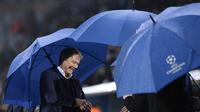 Pelatih Malmo FF, Age Hareide, memakai payung jelang laga Liga Champions melawan PSG di Swedia, Rabu (25/11/2015) WIB dini hari. (AFP Photo/Jonathan Nackstrand)