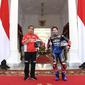 Presiden Joko Widodo berfoto dengan pembalap WithU Yamaha RNF MotoGP, Andrea Dovizioso di Istana Merdeka, Jakarta, Rabu (16/3/2022). Para pembalap datang dengan memakai setelah baju khusus balap motor yang akan dipakai dalam Grand Prix Indonesia di Mandalika. (Lukas - Biro Pers/Setpres)