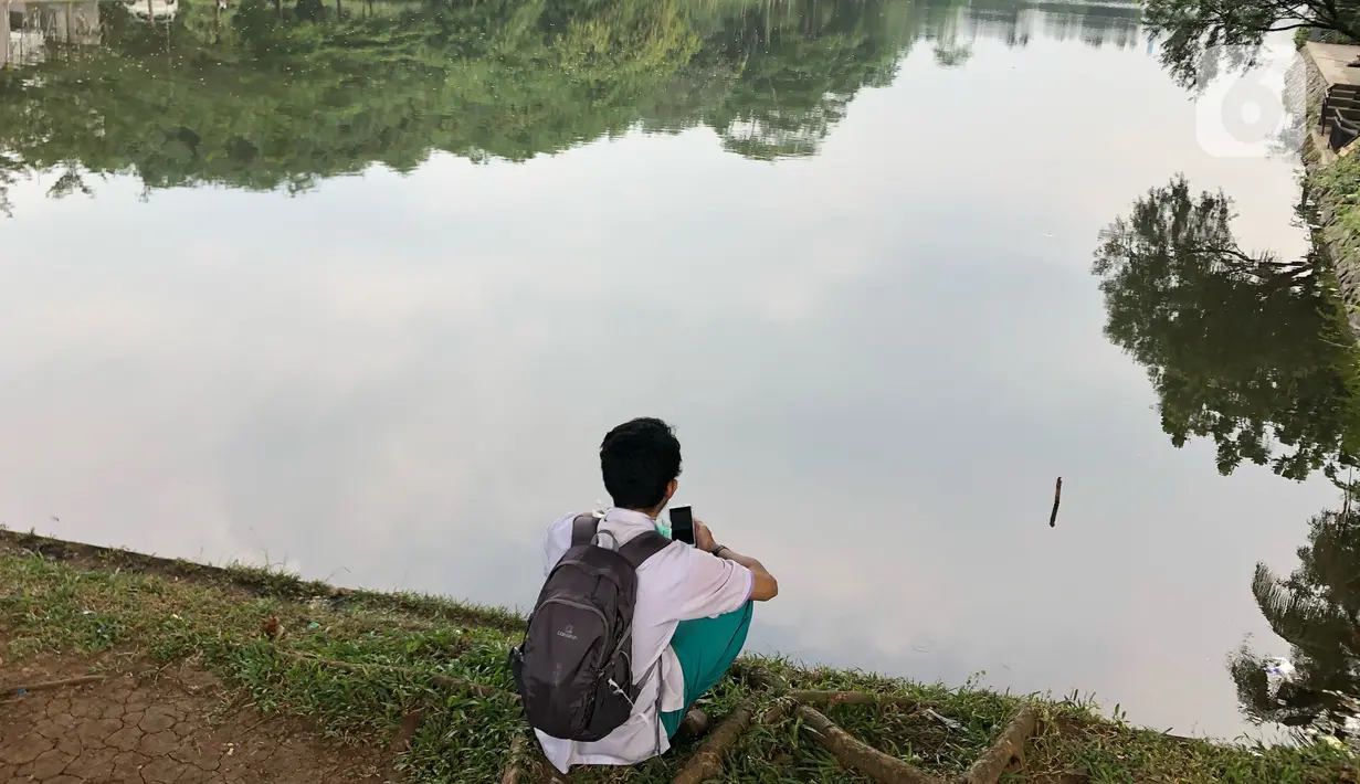 Warga beraktivitas di sekitar Setu Cibinong, Jawa Barat, Kamis (11/6/2020). Meskipun spanduk larangan penutupan telah dipasang, namun sebagian warga tetap nekat beraktivitas di kawasan tersebut untuk memancing ikan atau berekreasi. (Liputan6.com/Immanuel Antonius)
