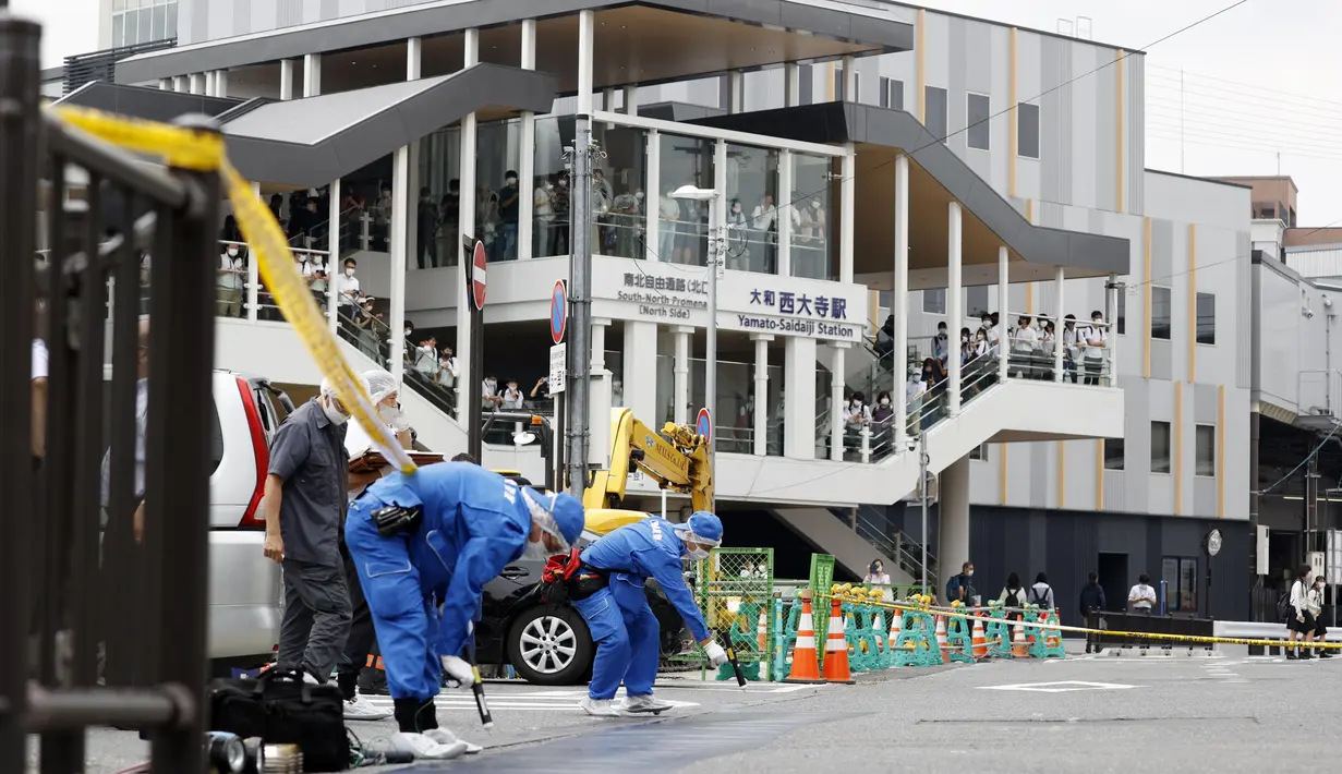 Polisi memeriksa lokasi di mana mantan Perdana Menteri Jepang Shinzo Abe ditembak di Nara, Jepang barat, Jumat (8/7/2022). Shinzo Abe Dilaporkan tidak menunjukkan tanda-tanda vital setelah ditembak di sebuah acara kampanye di wilayah Nara pada hari Jumat (8/7/2022). (Kyodo News via AP)