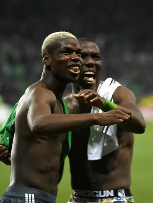 Gelandang Manchester United Paul Pogba (kiri) dan bek Saint-Etienne Florentin Pogba bertemu pada Liga Europa, di Stade Geoffroy-Guichard, Rabu (22/2). Pogba bersaudara saling bertukar jersey usai MU menang 1-0 atas Saint-Etienne. (PHILIPPE DESMAZES/AFP)