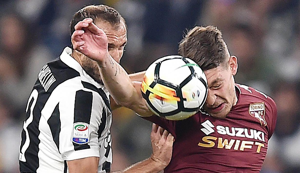 Bek Juventus, Giorgio Chiellini, duel udara dengan striker Torino, Andrea Belotti, pada laga Serie A, Italia, di Stadion Allianz, Sabtu (23/9/2017). Juventus menang 4-0 atas Torino. (AP/Alessandro Di Marco)