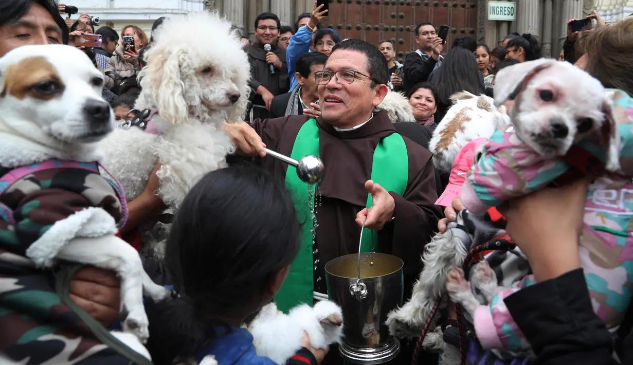 Imam Katolik Fermin Pena  melakukan pemberkatan pada hewan peliharaan dengan air suci di luar gereja San Francisco di Lima, Peru, Minggu (6/10/2019). Pemberkatan hewan ini untuk menghormati Santo Fransiskus yang dikenal sebagai santo pelindung bagi binatang dan lingkungan hidup. (AP/Martin Mejia)