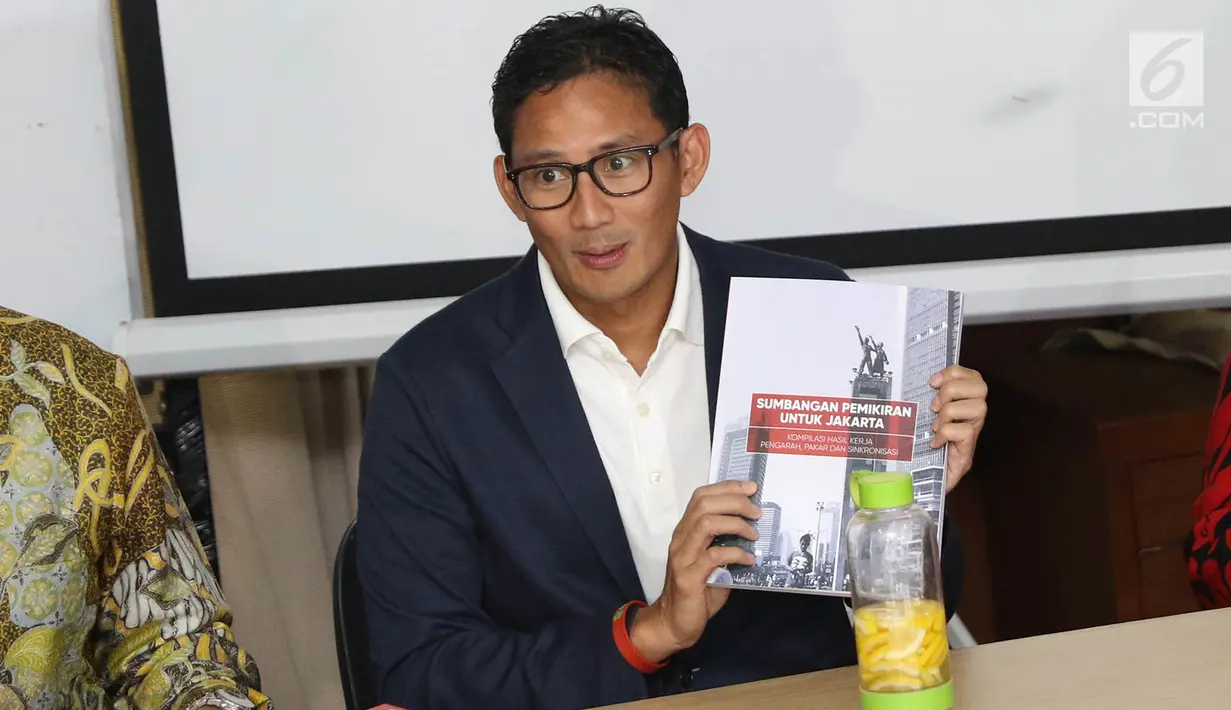 Wakil Gubernur terpilih DKI, Sandiaga Uno menunjukkan hasil kerja tim sinkronisasi seusai diserahkan di Jakarta, Jumat (13/10). Hasil kerja tim sinkronisasi yang dipimpin Sudirman Said itu dikerjakan selama masa transisi. (Liputan6.com/Immanuel Antonius)