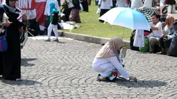 Peserta aksi memunguti ceceran sampah di halaman Monumen Nasional usai aksi, Jakarta, Jumat (11/5). Ribuan massa melakukan aksi menyoroti konflik Palestina dan Israel pada perebutan bangunan suci atau Baitul Maqdis. (Liputan6.com/Helmi Fithriansyah)