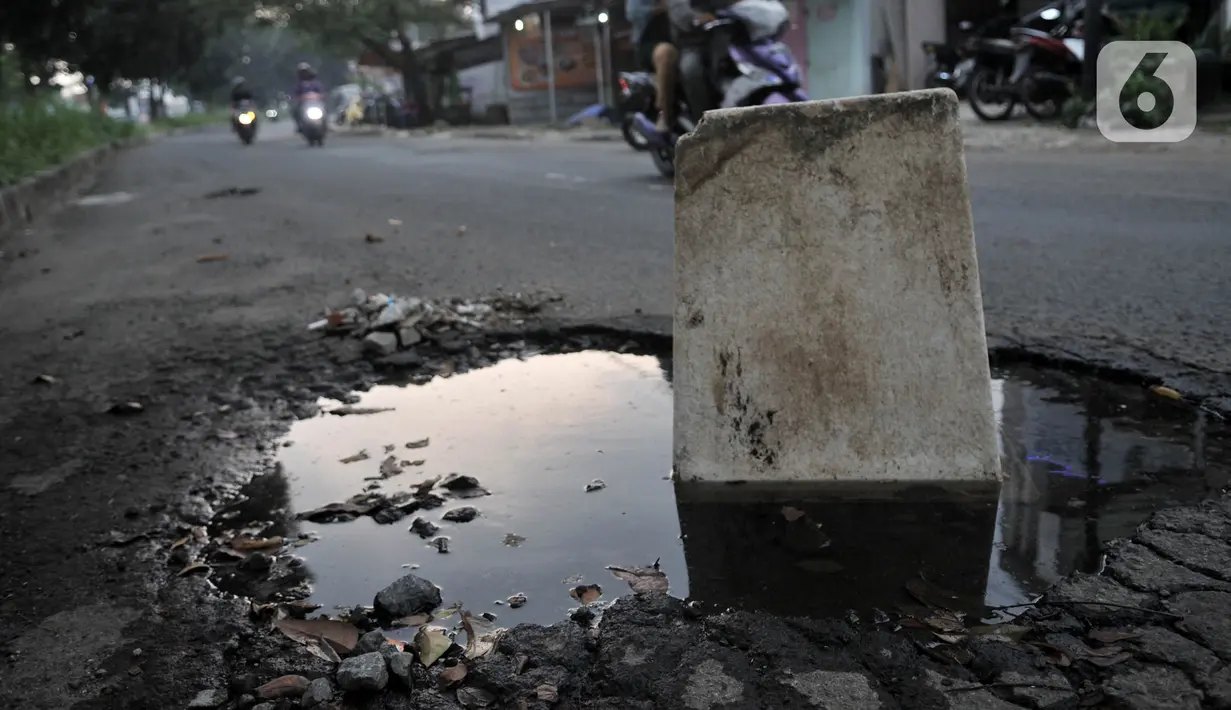 Tong sampah untuk menutupi jalan berlubang di Jalan Tegar Beriman, Cibinong, Bogor, Minggu (31/5/2020). Sudah berbulan-bulan akses yang dikenal sebagai jalan Pemda Cibinong ini sangat memprihatinkan hingga sering menyebabkan kecelakaan terlebih saat musim hujan. (merdeka.com/Iqbal Nugroho)
