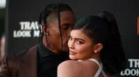 Travis Scott (kiri) mencium Kylie Jenner saat menghadiri pemutaran perdana Netflix "Travis Scott: Look Mom I Can Fly" di Barker Hangar, Santa Monica, California, Amerika Serikat, Senin (27/8/2019). Scott dan Kylie memamerkan kemesraan mereka di karpet merah.(Rich Fury/GETTY IMAGES NORTH AMERICA/AFP)