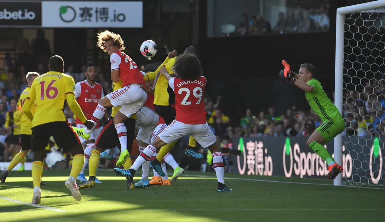 Bek Arsenal, David Luiz melompat melewati hadangan pemain Watford pada pekan kelima Liga Inggris 2019-2020 di Vicarage Road, Minggu (15/9/2019). Sempat unggul dua gol, Arsenal harus rela imbang 2-2 saat berjumpa tim tuan rumah Watford. (Ben STANSALL / AFP)