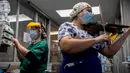 Perawat Chile, Damaris Silva memainkan biola untuk pasien yang terinfeksi COVID-19 di Unit Perawatan Intensif rumah sakit El Pino di Santiago pada 9 Juli 2020. Kegiatan tersebut dilakukan perempuan 26 tahun itu dua kali dalam seminggu setelah shift bekerjanya selesai. (Martin BERNETTI / AFP)