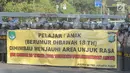 Aparat kepolisian membentangkan spanduk imbauan saat unjuk rasa massa di dekat Gedung DPR/MPR, Jalan Gatot Subroto, Jakarta, Senin (30/9/2019). Aksi unjuk rasa dari berbagai elemen tersebut menyikapi penolakan terhadap UU KPK dan sejumlah RUU yang dinilai bermasalah. (merdeka.com/Arie Basuki)