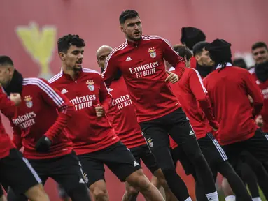 Penyerang Benfica, Roman Yaremchuk (tengah) dan rekan satu timnya melakukan pemanasan selama sesi latihan di tempat latihan Kampus Benfica di Seixal dekat Lisbon (14/3/2022). Benfica akan bertanding melawan Ajax pada leg kedua babak 16 besar Liga Champions di Amsterdam Arena. (AFP/Patricia De Melo M