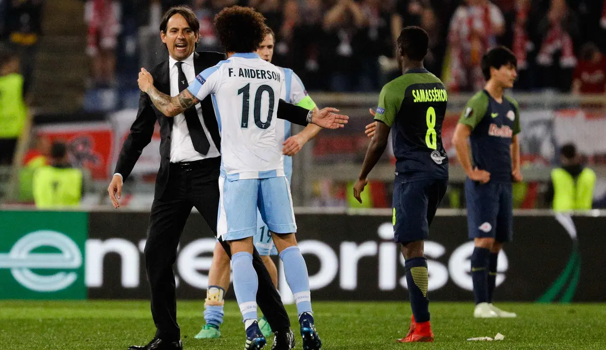 Pelatih Lazio, Simone Inzaghi memisahkan gelandang Marco Parolo saat memprotes wasit Ovidiu Hategan selama pertandingan melawan FC Red Bull Salzburg pada perempat final Liga Europa di stadion Olimpiade di Roma, Italia (5/4). (AP Photo / Gregorio Borgia)