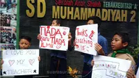 Guru dan murid SD Muhammadiyah 2 Surabaya menggelar aksi simpatik di depan sekolah, Jumat siang (2/2/2018). (Anggi suarasurabaya.net)