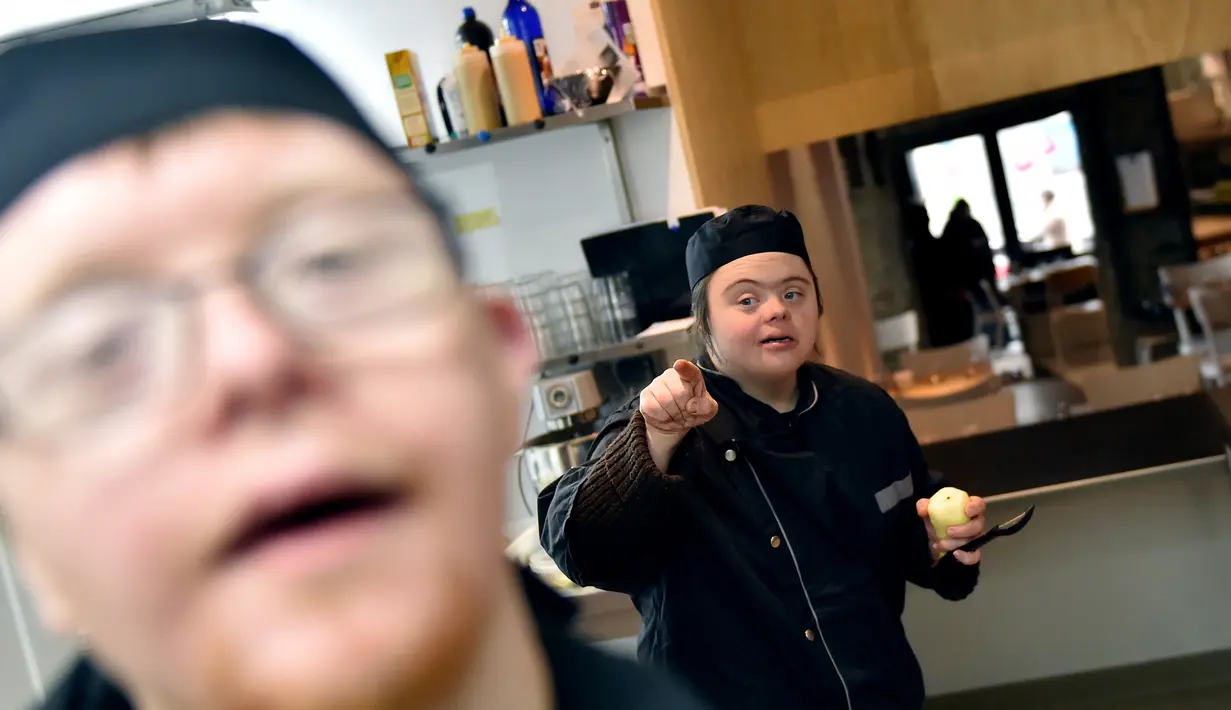 Asisten memasak dengan down syndrome beraktivtas menyiapkan makanan di dapur restoran "Le Reflet" di Nantes, Prancis Barat, 9 Februari 2017. Lelievre (26), mempekerjakan sejumlah karyawan yang memiliki down syndrome di restorannya. (LOIC VENANCE/AFP)