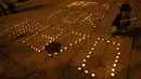 Seorang anak kecil tampak menyalakan lilin di samping pesan ajakan untuk mendoakan para korban Malaysia Airlines MH 370 (REUTERS / Edgar Su)