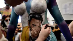 Seorang model menunjukkan tubuhnya dilukis oleh mahasiswa seni lembaga Chili AIEP selama pameran body painting, Santiago (24/11/2015). Lebih dari 100 desain yang terinspirasi oleh ikon musik, dipamerkan dalam pameran tersebut (AFP Photo/Martin Bernetti)