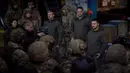 Presiden Ukraina Volodymyr Zelenskyy (kanan) berbicara kepada tentara di lokasi pertempuran terberat melawan Rusia di Bakhmut, Ukraina, 20 Desember 2022. Bakhmut merupakan sebuah kota yang diserang Rusia tanpa henti selama beberapa bulan. (Ukrainian Presidential Press Office via AP)