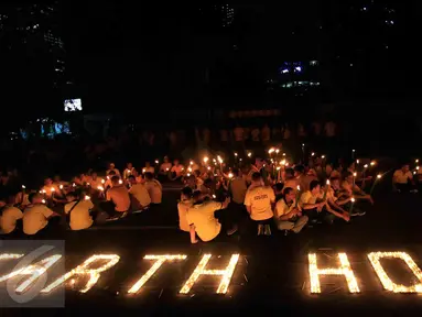 Puluhan karyawan Artha Graha Peduli menggelar aksi Earth Hours dengan menyalakan lilin di kawasan SCBD Jakarta, Sabtu (25/3) malam. Aksi tersebut sebagai bentuk kepedulian dalam mengurangi emisi gas rumah kaca di kawasan SCBD. (Liputan6.com/Fery Pradolo)