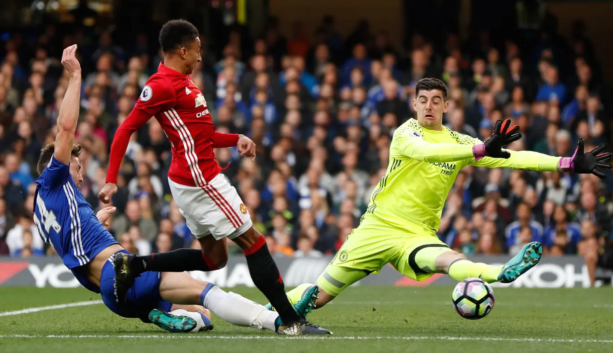 Kiper Chelsea, Thibaut Courtois berusaha menghalau tendangan gelandang MU, Jesse Lingard pada Liga Inggris di Stadion Stamford Bridge, London, Inggris (23/10). Chelsea menang atas MU dengan skor akhir 4-0. (Reuters/John Sibley)