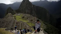 Seorang wanita tampak berfoto dengan pemandangan reruntuhan Kerajaan Inca di Pegunungan Machu Picchu , Peru, Rabu (12/8/2015). Pemerintah setempat membatasi wisatawan yang masuk ke Machu Picchu yang hanya menerima 2.500 wisatawan. (REUTERS/Pilar Olivares)