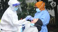 Tenaga kesehatan melakukan kegiatan tes swab massal di Puskesmas Ciganjur, Jakarta, Kamis (7/1/2020). Lonjakan kasus virus corona berpotensi terjadinya krisis tenaga kesehatan (nakes) karena banyak yang tertular dan gugur saat menangani pasien Covid-19. (merdeka.com/Arie Basuki)