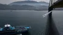 Sebuah kapal melintas saat koreografer dan penari "ekstrem", Katerina Soldatou melakukan tarian di bawah jembatan Rio-Antirio, Yunani selatan, Senin (12/3).  Jembatan ini merupakan jembatan bentang kabel terpanjang di dunia. (AP Photo/Petros Giannakouris)
