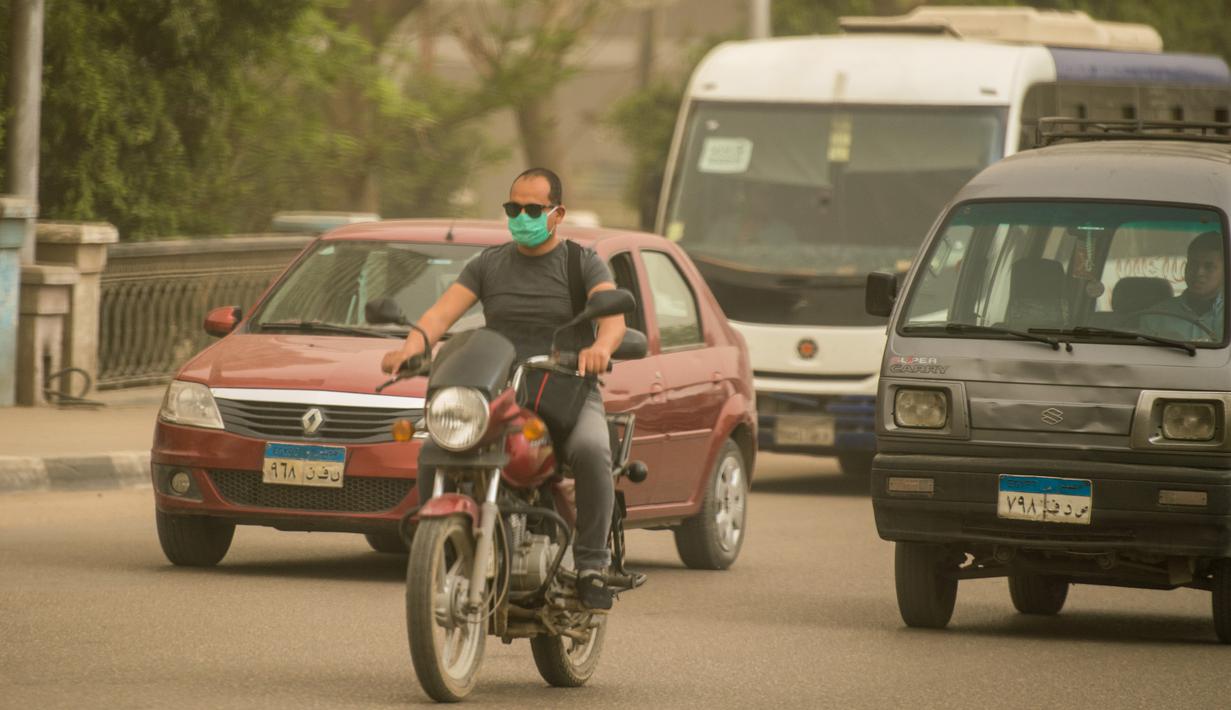 Seorang pria yang mengenakan masker mengendarai sepeda motor di sebuah jalan di Kairo, Mesir, pada 5 April 2020. Mesir pada Sabtu (4/4) melaporkan lima kematian baru akibat infeksi COVID-19, menjadikan total kasus kematian di negara tersebut mencapai 71. (Xinhua/Wu Huiwo)