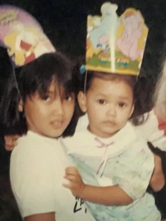 Keduanya sudah kompak sejak kecil, Sara nampak menggendong Adinia yang mengenakan dress hijau saat masih kecil. (@sarawijayanto)