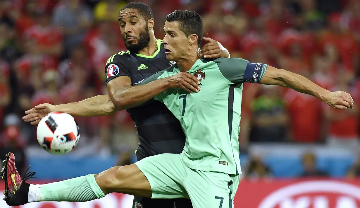 Cristiano Ronaldo berebut bola dengan pemain Wales dalam pertandingan semifinal Euro 2016 antara Portugal melawan Wales di stadion Parc Olympique Lyonnais pada 6 Juli 2016. (AFP/Philippe Desmazes)