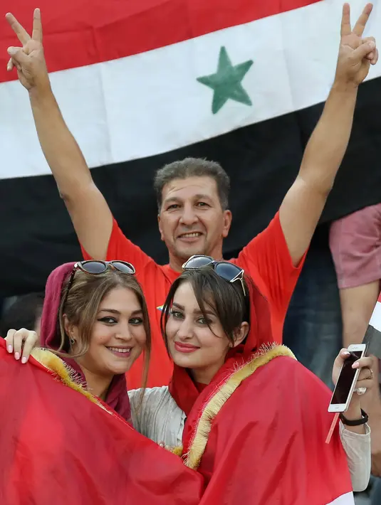 Suporter Suriah memberi dukungan saat laga kualifikasi Piala Dunia 2018 melawan Iran di Stadion Azadi, Tehran, Selasa (5/9/2017). Finis urutan tiga grup A, Suriah lolos ke babak playoff untuk menantang Australia. (AFP/Atta Kenare)