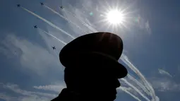 Siluet Angkatan Bela Diri Jepang (SDF) dengan latar belakang pertujukan akrobatik pesawat udara Jepang saat upacara tahunan Pasukan Bela Diri (SDF) di Pangkalan Asaka, Jepang(23/10). (Reuters/Kim Kyun-Hoon)