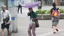 Seorang wanita berusaha memegangi payungnya saat angin kencang akibat topan jebi di Yokohama, dekat Tokyo, (4/9). PM Shinzo Abe mendesak warga segera dievakuasi dan meminta pemerintah mengambil seluruh langkah. (AP Photo/Koji Sasahara)
