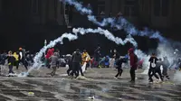 Pengunjuk rasa antipemerintah mengembalikan tabung gas air mata ke polisi saat bentrokan di Bogota, Kolombia, Rabu (5/5//2021). Protes yang diikuti ribuan orang ini sudah memasuki pekan kedua. (AP Photo/Fernando Vergara)