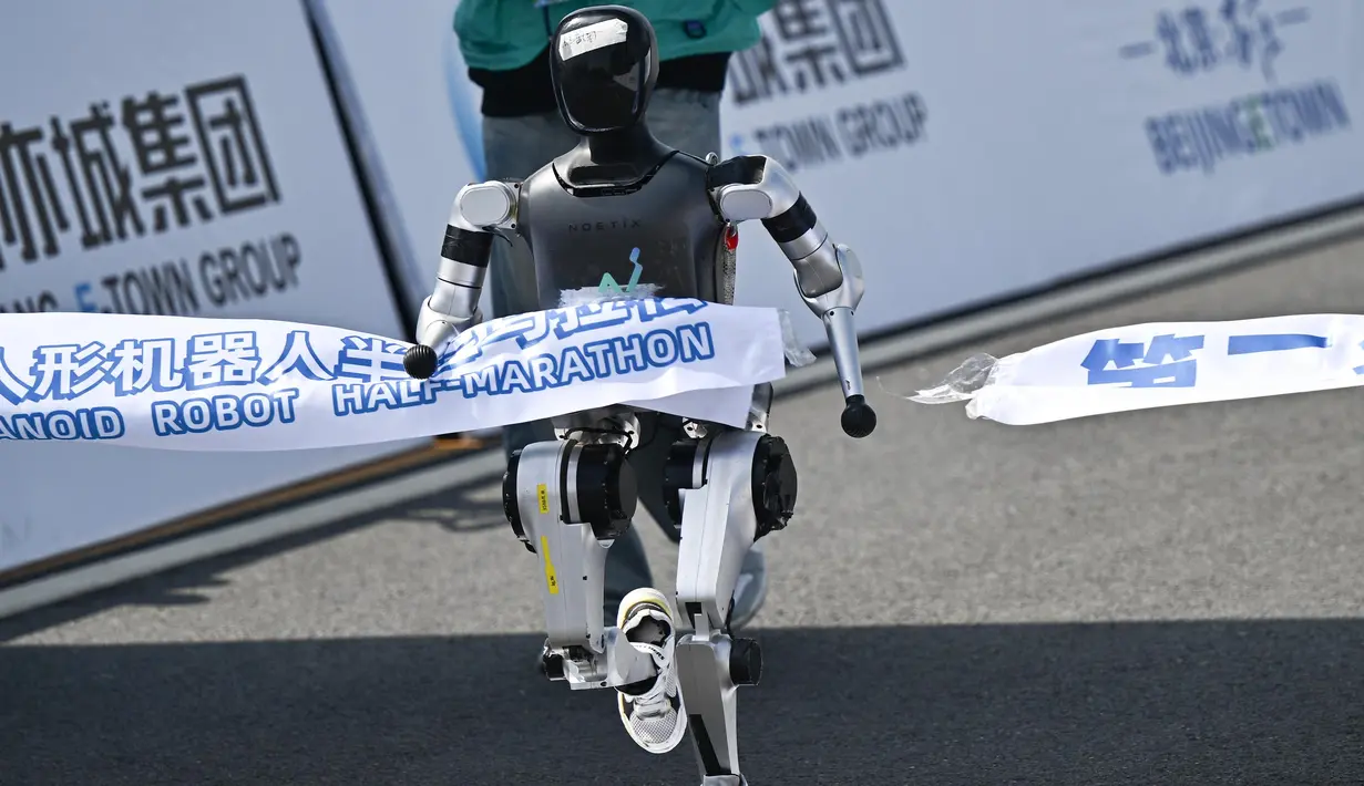 Sebuah robot melintasi garis finis dalam lomba lari setengah maraton robot humanoid di Beijing pada 19 April 2025. (Pedro PARDO/AFP)