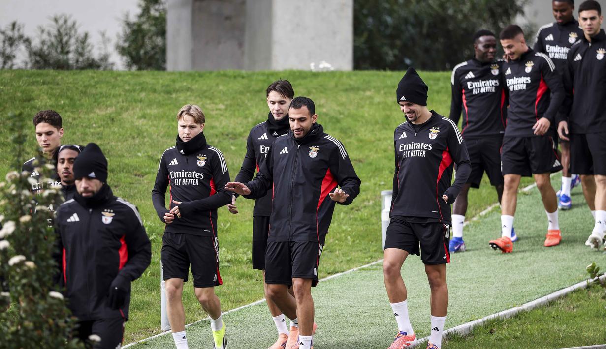 Pertarungan kedua tim ini akan menjadi ajang pembuktian bagi kedua tim yang memiliki ambisi besar di kompetisi paling bergengsi Eropa. Tampak dalam foto, penyerang SL Benfica asal Yunani, Vangelis Pavlidis (tengah) bersama rekan-rekan setimnya berjalan untuk sesi latihan menjelang leg pertama play-off Liga Champions 2025/2026 melawan Real Madrid di Kampus Benfica, Seixal, pinggiran Lisbon, Portugal, pada Senin 16 Februari 2026. (PATRICIA DE MELO MOREIRA/AFP)